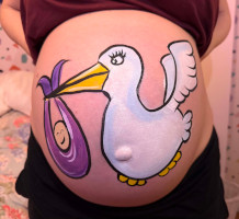 Pregnant woman with stork holding a purple cloth wrapped baby