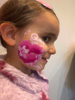 Girl with pink heart on her cheek